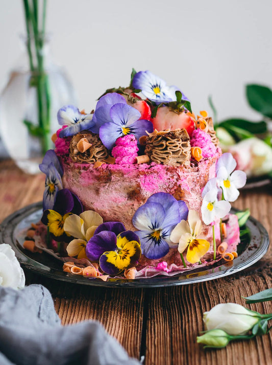 En mini vegansk vaniljkaka med kaffebuttercream och jordnötssmörsfrosting (med en rosa twist av rödbetspulver 💗), dekorerad med massor av ätbara blommor.